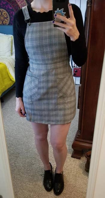 a reviewer wearing the same dress featuring a black and white plaid print 