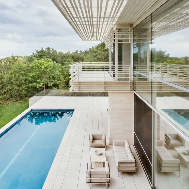 a modern house with a pool and white furniture