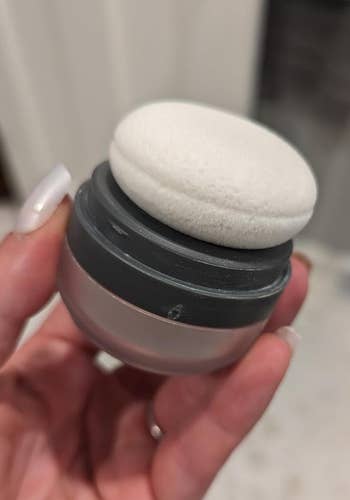 a handing the jar of dry shampoo