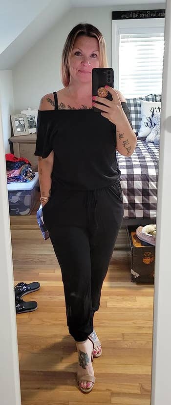 reviewer wearing the black off-the-shoulder jumpsuit