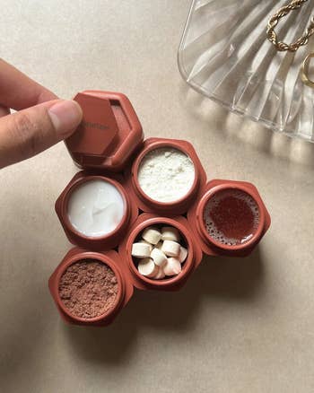 six red cadence capsules filled with vitamins and skincare goods