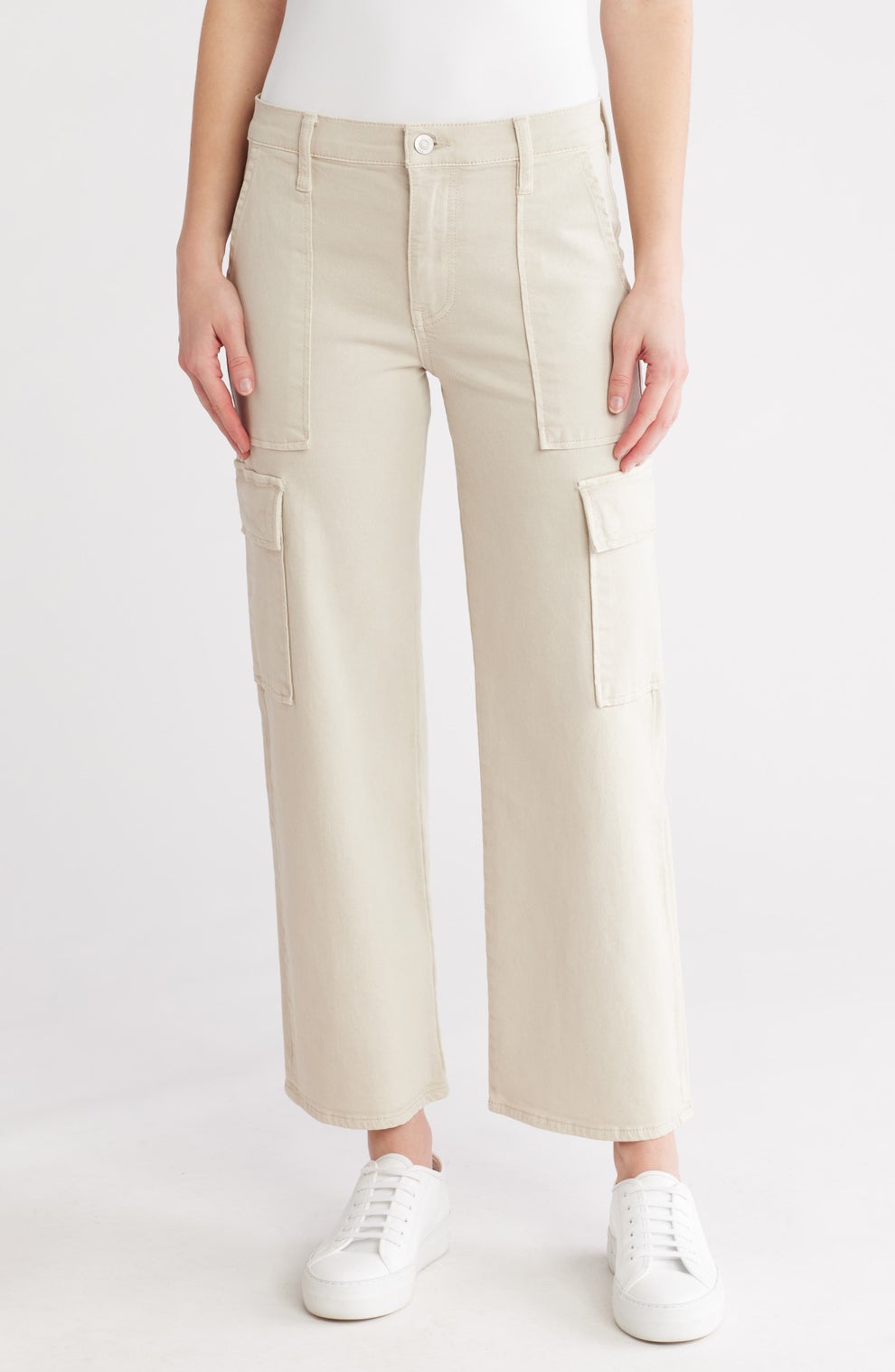 Person wearing cargo pants with wide legs and sneakers, posing for a fashion photo