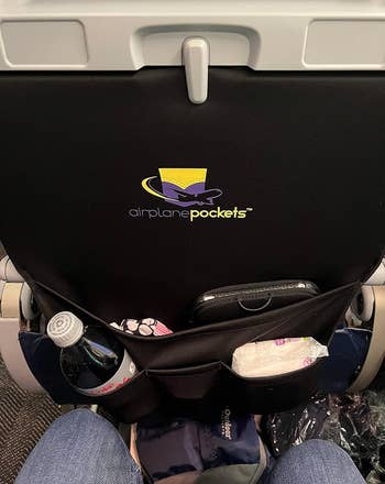 A reviewer with their soda bottle, baby wipes, and other personal items in the cover