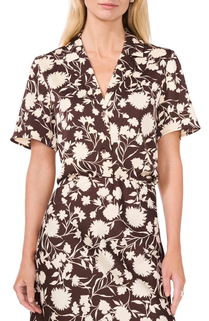 Person wearing a floral-patterned, short-sleeve dress with a V-neck collar