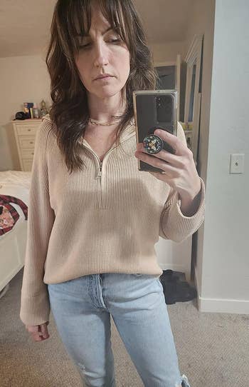 a reviewer wearing the sweater in tan 