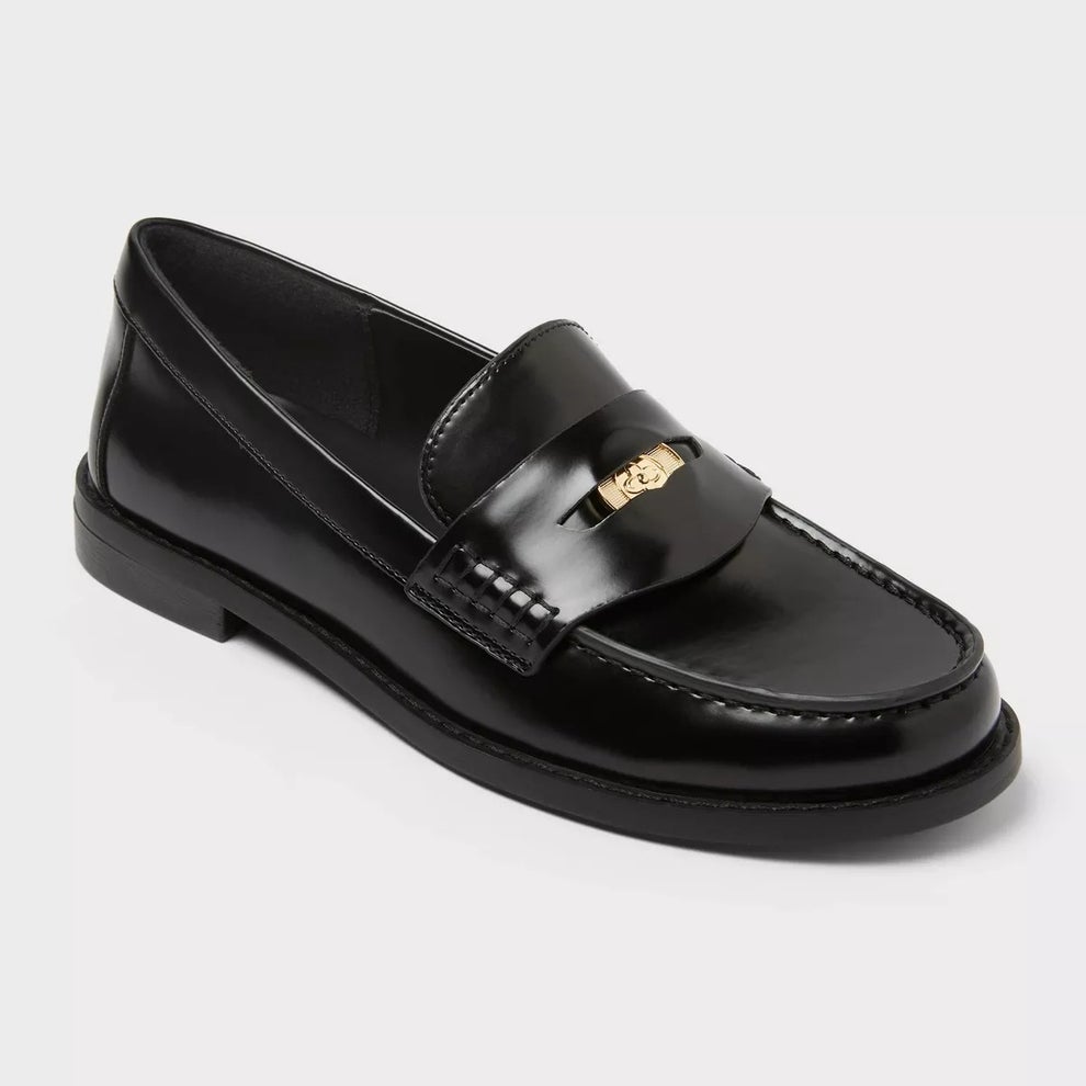 Black faux leather loafer with a gold emblem on the strap