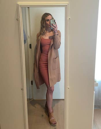 Reviewer wearing the khaki colored cardigan with a dress
