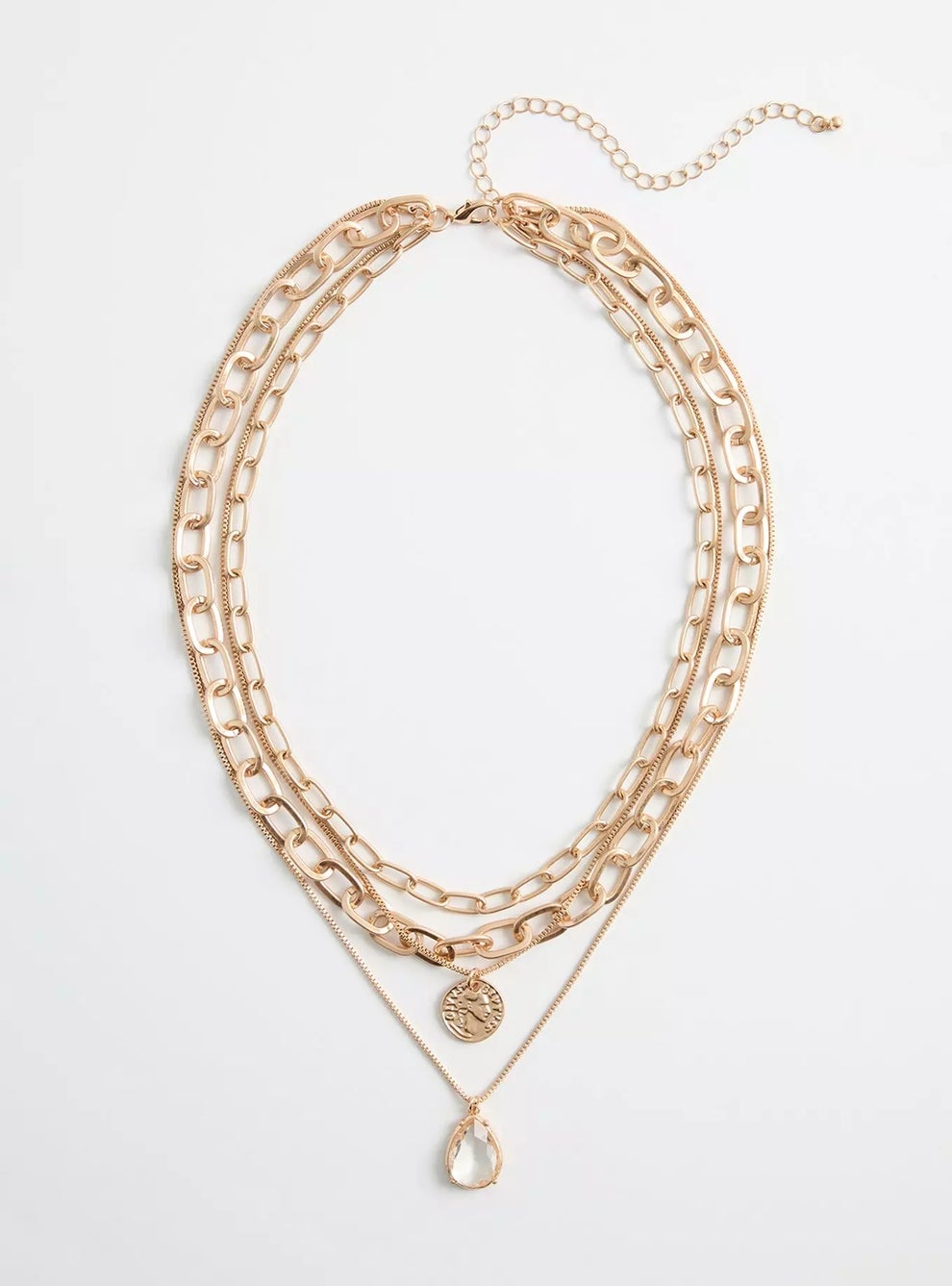 Layered gold-tone necklace with chain links, coin pendant, and teardrop charm on a white background