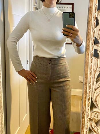 Reviewer wearing the white sweater with brown trousers