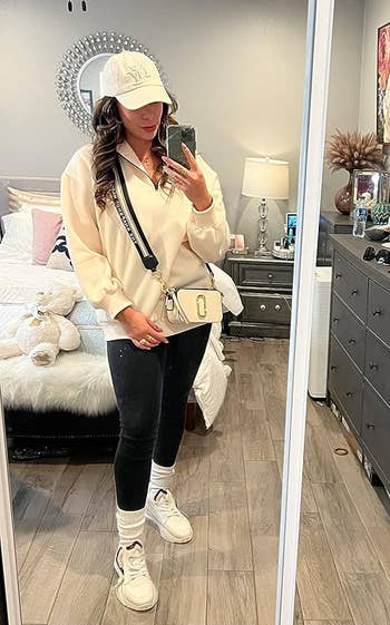 A reviewer wearing the cream-colored sweatshirt