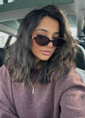 reviewer wearing the oval sunglasses