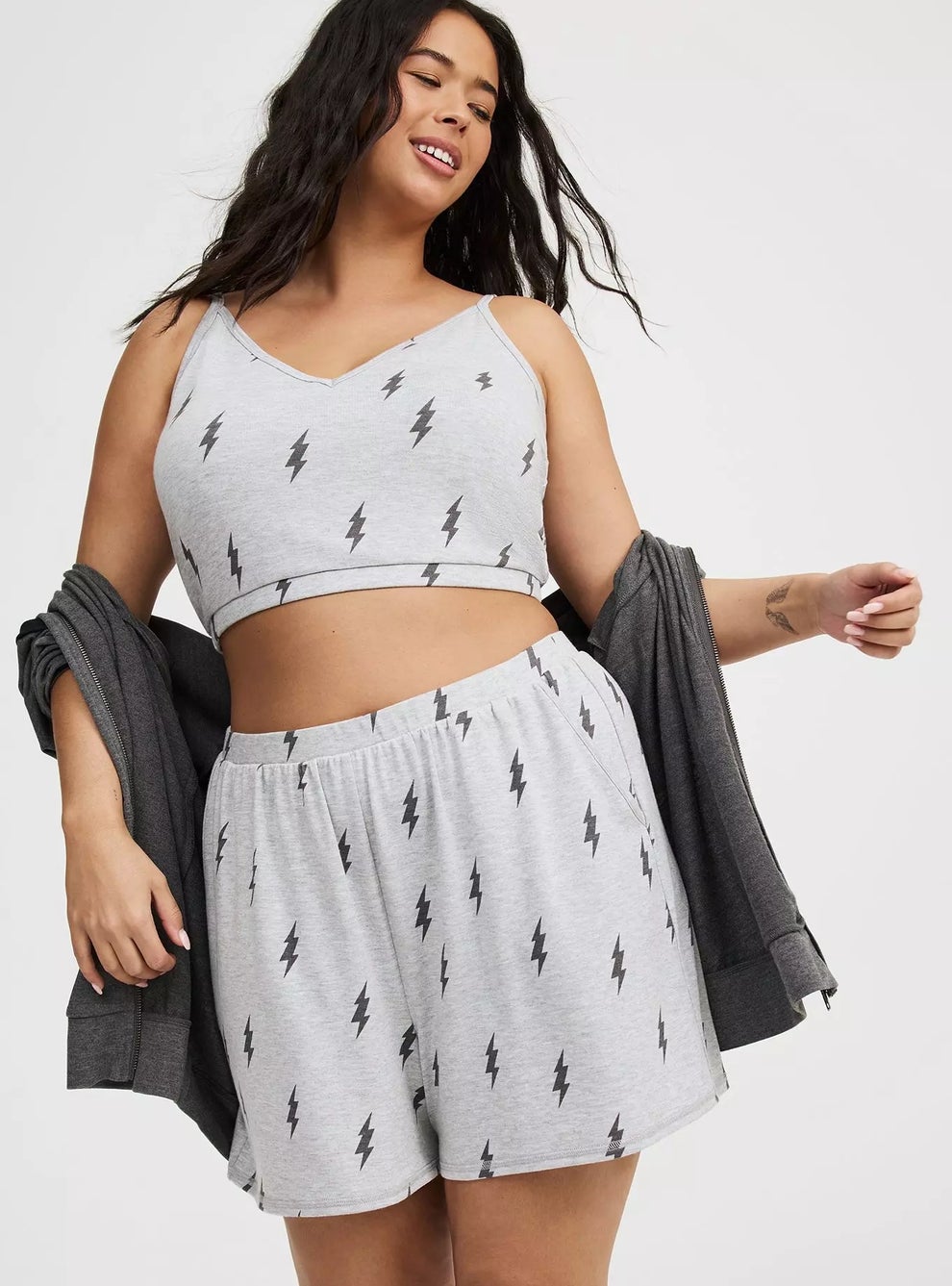 Person wearing a gray pajama set with lightning bolt pattern, posing with a matching robe