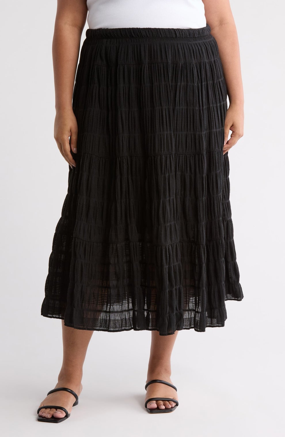Person wearing a pleated midi skirt and sandals