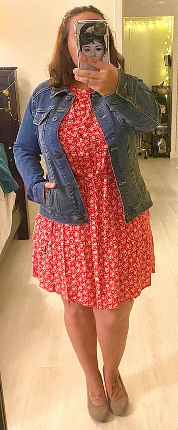 Reviewer wearing the blue jean jacket with a red dress