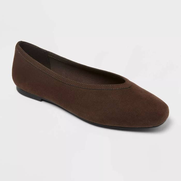 Brown suede ballet flat shoe with a minimalist design, featuring a rounded toe and a thin sole