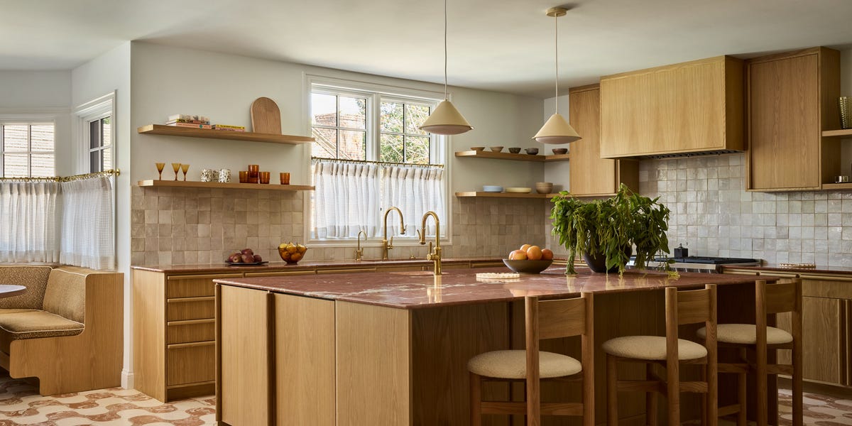 Modern kitchen with wooden cabinetry and marble island.