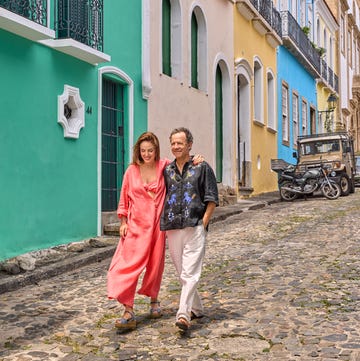 couple walking down a colorful street with cobblestones