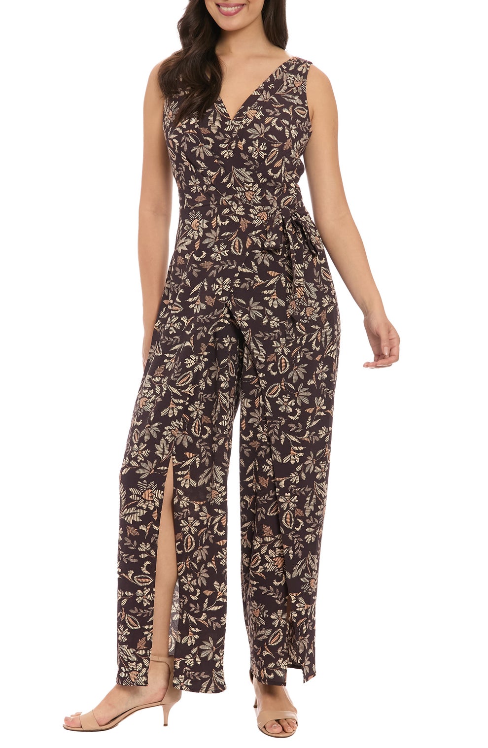Person wearing a sleeveless floral jumpsuit with wide legs and high heels, standing in a relaxed pose