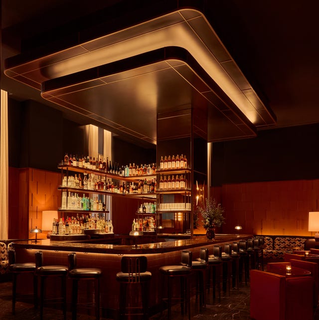 stylish bar interior with a long counter and a wellstocked shelf of liquor bottles