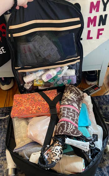 open backpack stuffed full of things for a long weekend. 