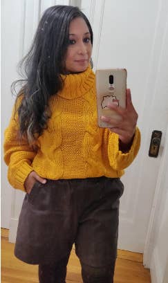 Reviewer wearing the yellow chunky knit sweater and shorts