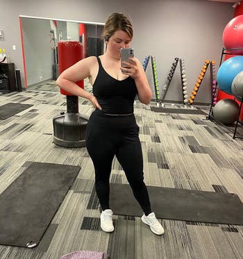 reviewer taking a mirror picture at the gym while wearing the black joggers