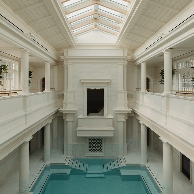 an roman atrium with balconies overlooking a large pool