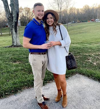 reviewer wearing the white sweater as a dress with booties