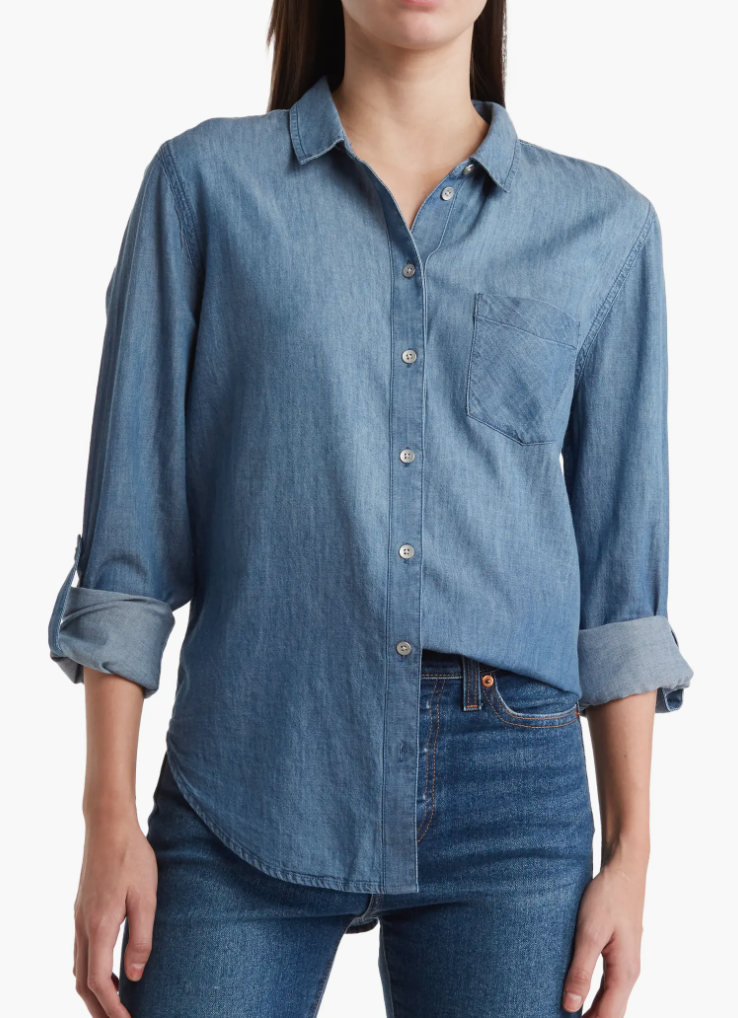 Person wearing a rolled-up sleeve denim shirt and jeans, showcasing casual fashion for a shopping article