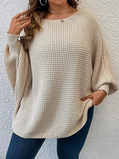 A person is wearing a loose, textured knit sweater with long sleeves and dark pants