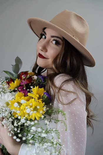 Reviewer wearing the white shirt holding flowers