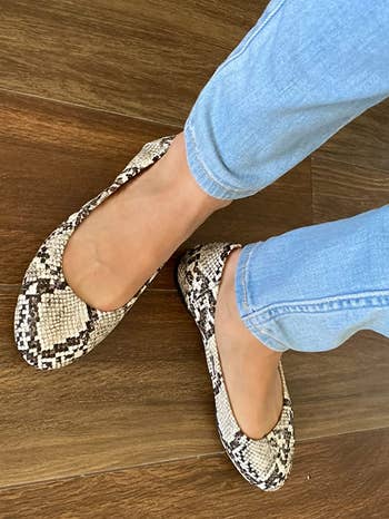 reviewer wearing snakeskin flats with jeans