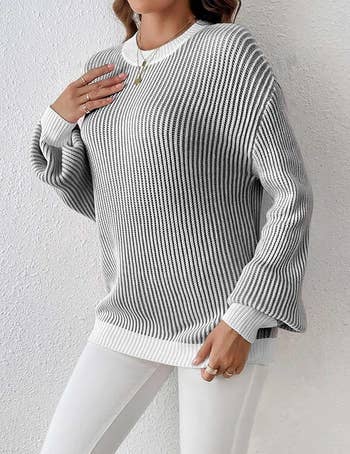 A model in gray and white ribbed knit pullover sweater with long sleeves