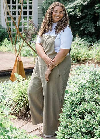 reviewer wearing the sage green romper over a white top