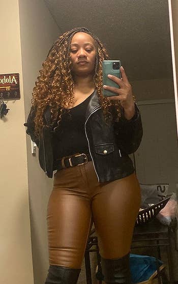 A reviewer wearing the black jacket with brown leather pants